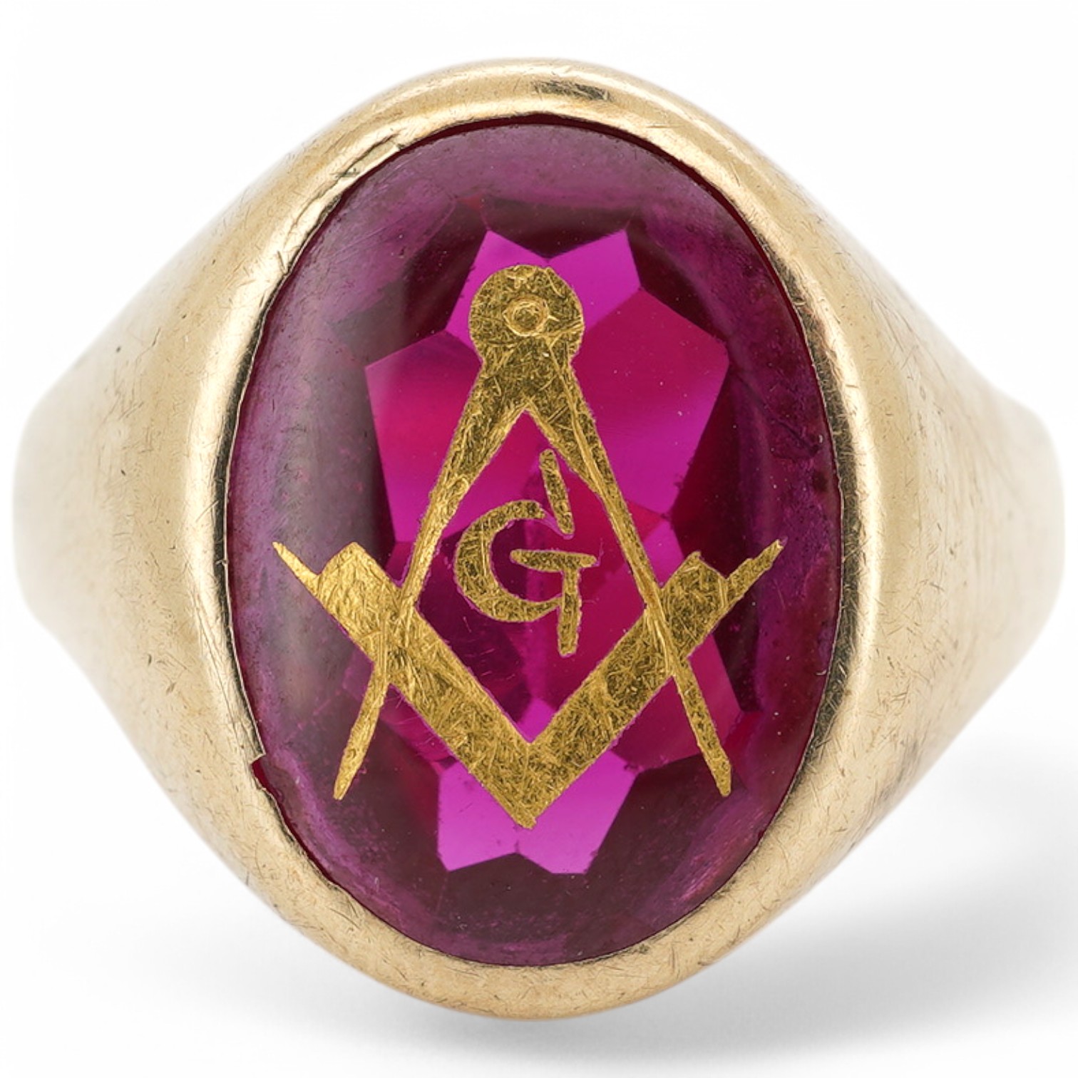 A 9ct and synthetic ruby set signet ring, the stone carved with gilded masonic symbol, size S/T, gross weight 5.8 grams. Condition - fair to good